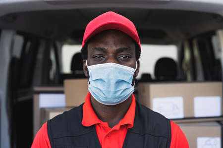 African delivery man working while wearing face mask to avoid   virus spread - People working with...