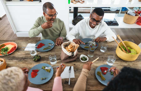 Happy black family eating healthy lunch together at homeの写真素材