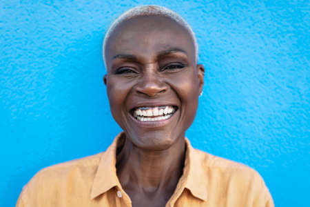 Happy African woman portrait - Afro senior female having fun smiling while posing in front of cameraの写真素材