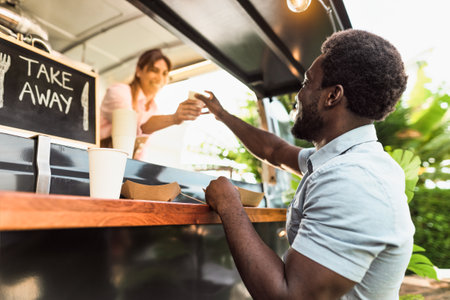 Young African man buying meal from food truck - Modern business and take away conceptの写真素材