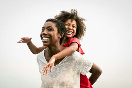 Happy African family on the beach during summer holidays - Afro people having fun on vacation time - Parents love and travel lifestyle conceptの写真素材