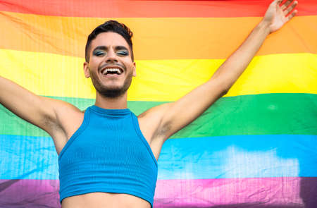 Happy homosexual man celebrating gay pride holding rainbow flag symbol of LGBTQ communityの写真素材