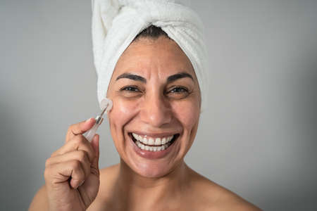 Happy Latin mature woman having skin care spa day - People wellness lifestyle concept