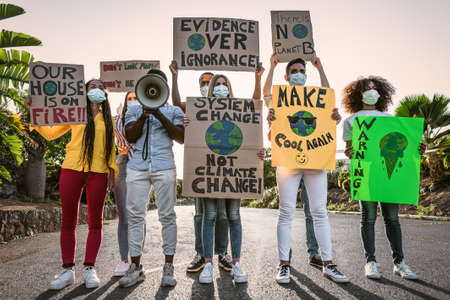 Group of activists protesting for climate change - Multiracial people fighting on road holding...