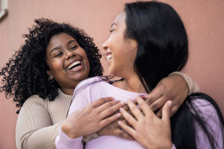 Happy Latin girls having fun embracing outdoor - Young people lifestyle and friendship conceptの写真素材