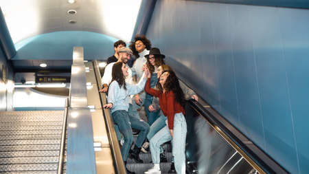 Happy young friends hanging out in metropolitan underground subwayの写真素材