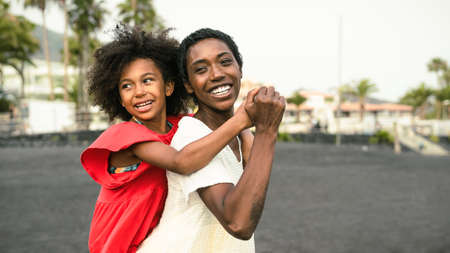 Happy African family on the beach during summer holidays - Afro people having fun on vacation time - Parents love and travel lifestyle conceptの写真素材