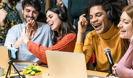 Young people recording a podcast using microphone and laptop from home studio - Youth millennial generation and technology conceptの写真素材