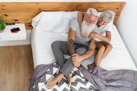 Happy senior couple having tender moments in the bedの写真素材
