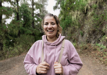 Happy woman having a walk in the woods - Adventure and travel people concept