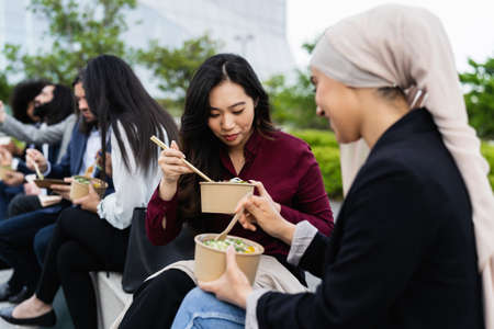 Multiracial business people taking a break eating a meal outside the officeの写真素材