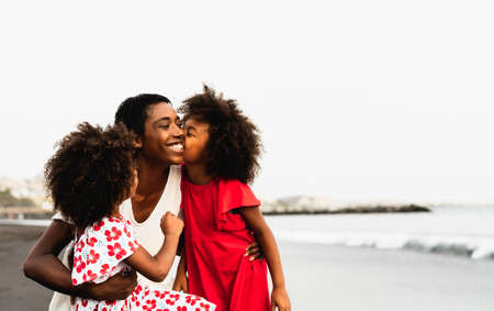 Happy African family having fun on the beach during summer vacationsの写真素材
