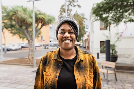 Happy African woman smiling in front of a camera in the cityの写真素材