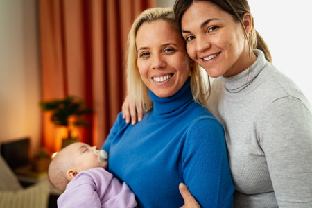 Happy lesbian couple with little baby at home portrait - LGBT family conceptの写真素材