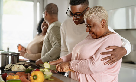 Happy African family preparing food recipe together in modern kitchen - Food and parents unity conceptの写真素材