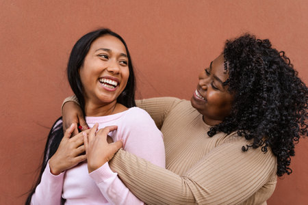 Happy Latin girls having fun embracing outdoor - Young people lifestyle and friendship conceptの写真素材
