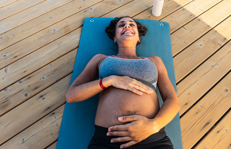 Top view of happy pregnant woman caressing her belly outdoor - Health lifestyle and maternity conceptの写真素材