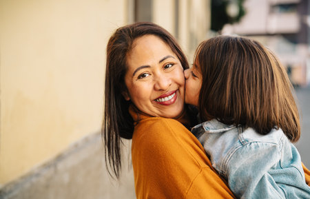 Happy filipina mother with her daughter having tender moments in the city center - Lovely family outdoorの写真素材