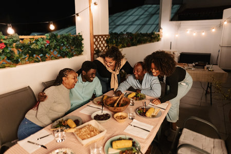 Happy African family dining together on house patioの写真素材