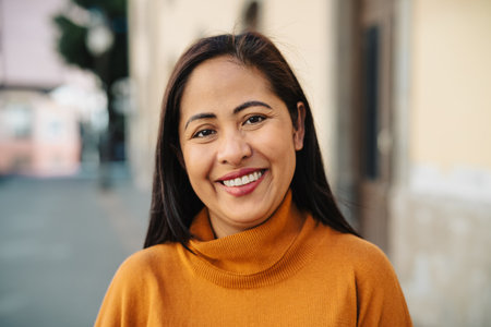 Happy filipina woman having fun smiling in front of camera in the city centerの写真素材