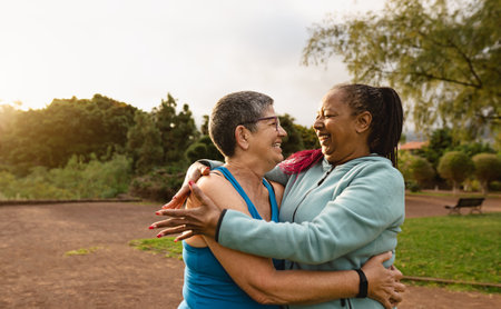 Happy multiracial senior women having fun after workout activities in a public park - Health elderly people conceptの写真素材