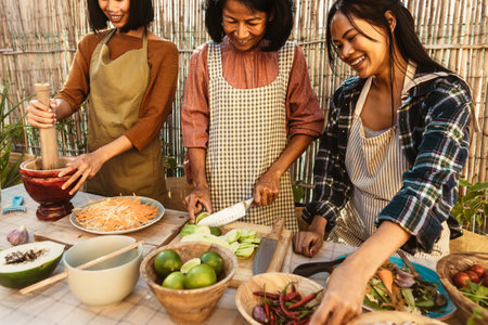 Happy Southeast Asian family having fun preparing Thai food recipe together at house patio