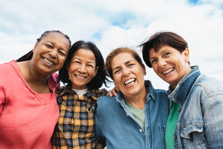 Happy multiracial senior women having fun smiling into the camera at house rooftopの写真素材