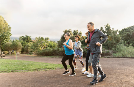 Group of diverse senior people jogging together at parkの写真素材