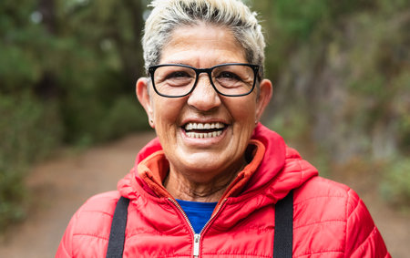 Happy senior woman having fun during trekking activities day in the woods - Adventure and travel people conceptの写真素材