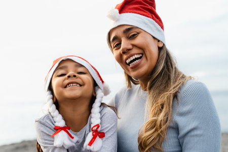 Happy Latin mother with her daughter enjoying Christmas holidays - Family and holidays conceptの写真素材