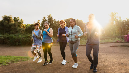 Group of diverse senior friends jogging together at parkの写真素材
