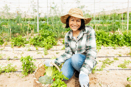 Happy southeast Asian woman working inside agricultural greenhouse - Farm people lifestyle conceptの写真素材