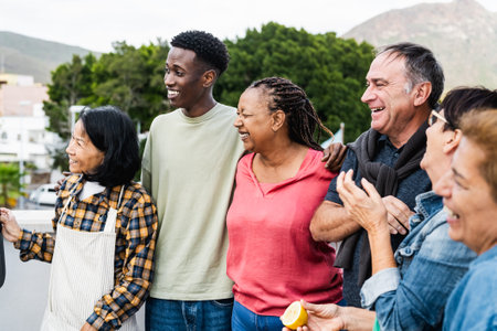 Happy multigenerational friends having fun preparing food at house rooftop - Diversity people lifestyleの写真素材