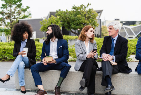 Multiracial business people with different ages having lunch break outside officeの写真素材