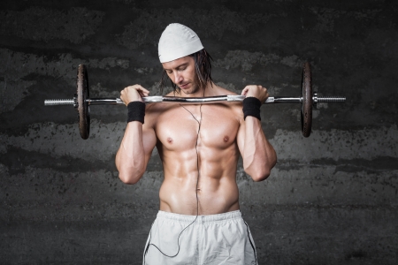 muscle bodybuilder lifiting weigths while listening to musicの写真素材