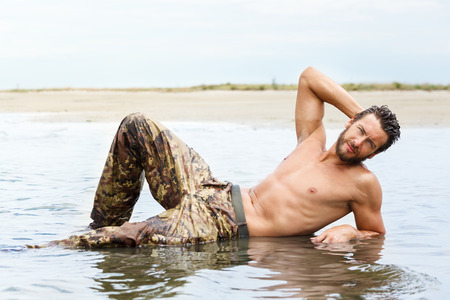 Portrait of Muscle man during fitness training on the water oceanの写真素材