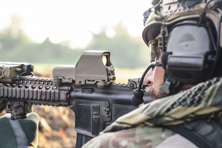 Side view of American Soldier aiming a rifle