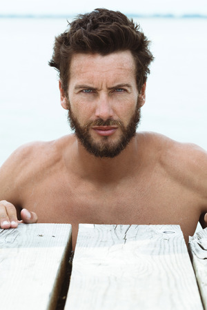 Close up Portrait of Confident Athletic Handsome Man with No Shirt Posing at the Seaの写真素材