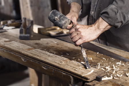 hands of carpenter plane on the wooden workbench in carpentryの写真素材