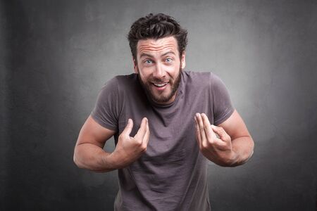 Frontal portrait of adult man getting surprised unexpected attention from people, asking you talking...