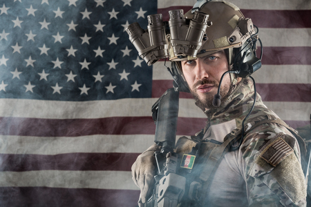 Portrait of Bearded US Army Soldier With Night Vision Goggles on American Flag Background; Smoke Cloudの写真素材