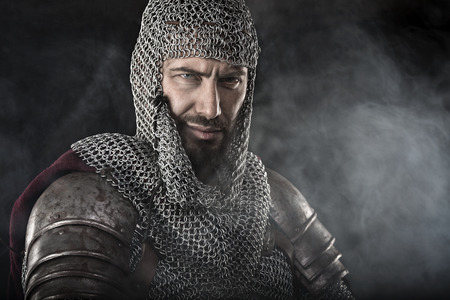 Portrait of Medieval Dirty Face Warrior with chain mail armour. Smoke Cloud on Dark Backgroundの写真素材