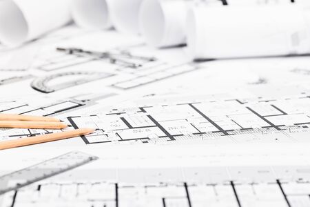 Construction plans with drawing tools on blueprints; Architectural and engineering housing concept.