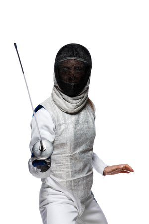 Portrait of Young woman fencer wearing mask and white fencing costume. Attacking pose. Isolated on White Backgroundの写真素材