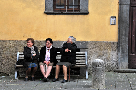 Old women sitting on a bench during religious celebration in Bagnoregio, Italyのeditorial素材