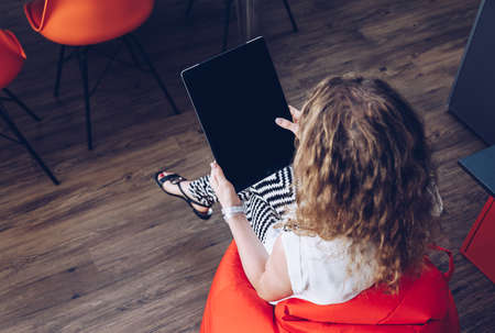 Young girl using a big tablet with touch gesture & pointing finger tap simulation in a smart moder...