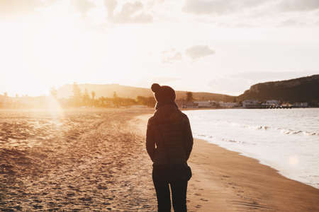 Girl walking on the beach at sunset - winter season - story telling sequence.の写真素材