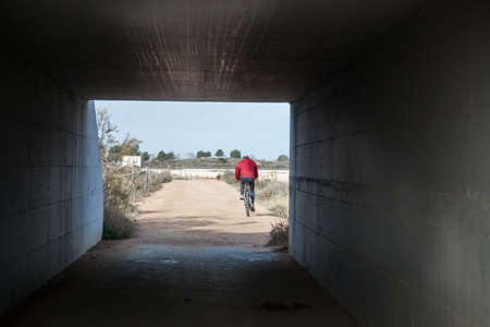 Alone aged biker along the path of Salt field - Sardinia.の写真素材