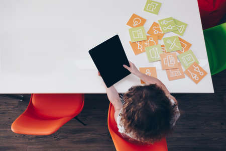 Aerial view of a young girl using a big tablet with touch gestureの写真素材
