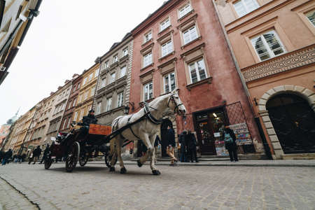 WARSAW, POLAND - Mar, 2018 Tourists ride in a carriage with horses in the historic part of the city of Warsaw 1のeditorial素材